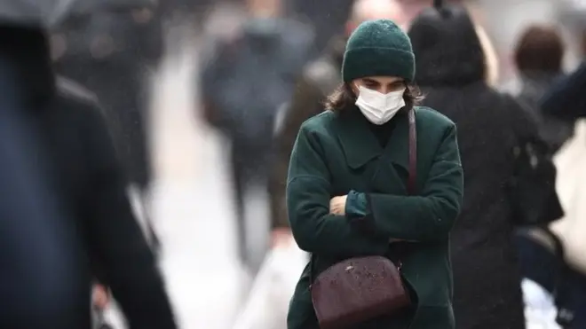 A woman, wearing a protective mask, walks on Montorgueil street in Paris amid the coronavirus disease (COVID-19) outbreak in France, December 3, 2021.