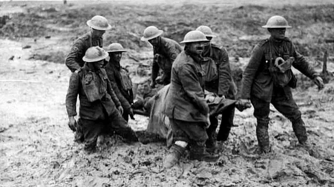 Soldados sacan del lodo a un compañero muerto en combate.