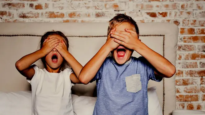 आंखों पर हाथ रखे दो बच्चे