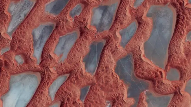 Grant memberi judul foto ini The Empty Quarter, Saudi Arabia. Ini adalah gurun kosong seluas kira-kira 349,6 km persegi. Bagian yang berwarna kebiru-biruan adalah danau-danau kuno yang airnya mengering.