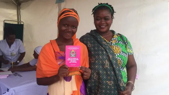 Binti akionesha kadi yake baada ya kupokea chanjo