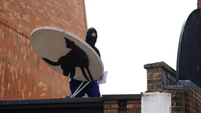 Simljen je muškarac kako skida satelitsku antenu