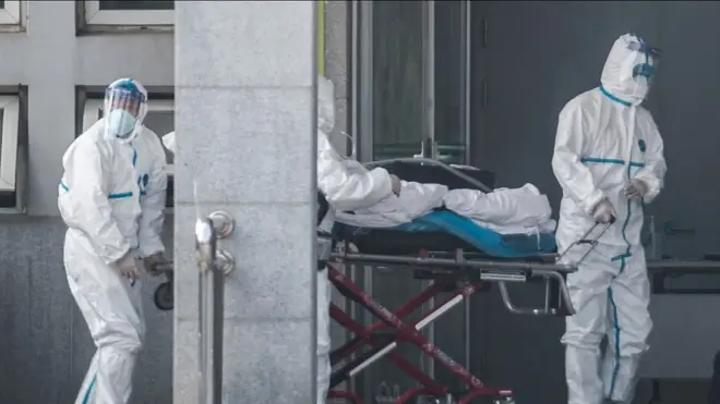 中国武汉医务人员全副武装过运送新型冠状病毒感染肺炎感染者