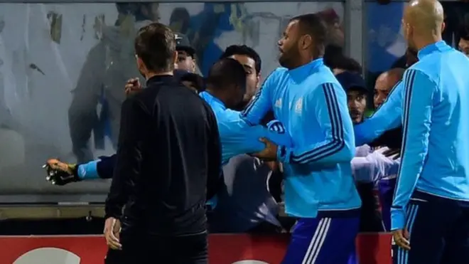 Los compañeros de Evra apartan al futbolista tras su acrobática patada.