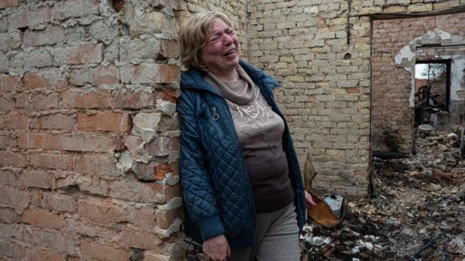 一名婦女在烏克蘭奧澤拉被燒燬的房子裏哭泣
