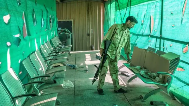 جندي أفغاني يتفقد ما تركه الأمريكيزن في قاعدة باغرام