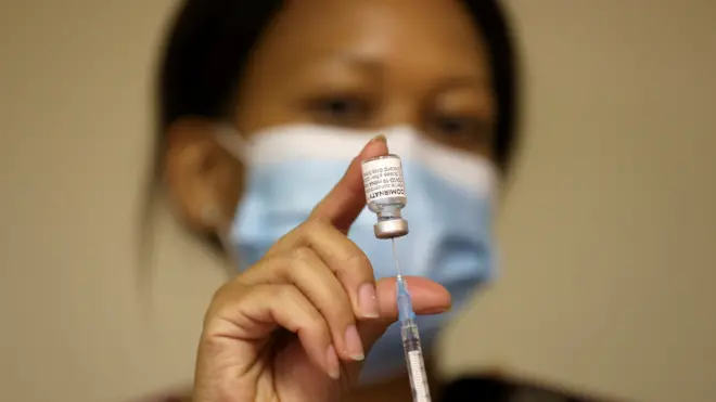 A health worker holds a vial of the Pfizer/BioNTech coronavirus disease (COVID-19) vaccine, at the Munsieville Care for the Aged Centre outside Johannesburg, South Africa May 17, 2021.