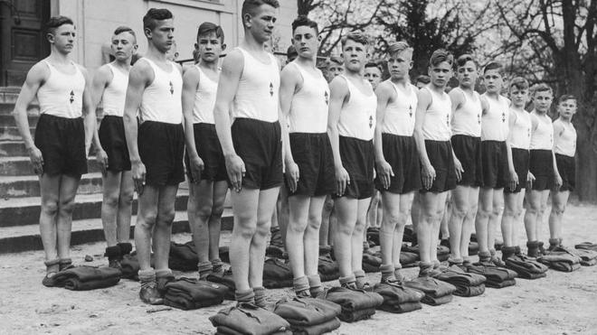 Un grupo de jóvenes desfilando con ropa deportiva en una Napola, alrededor de 1935.
