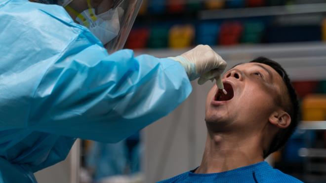 一名男士在香港伊利莎伯体育馆采样点接受新冠病毒检测采样（1/9/2020）