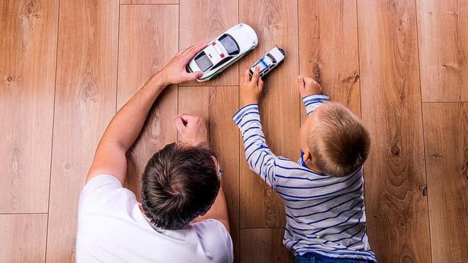 Padre e hijo juegan con coches de juguete