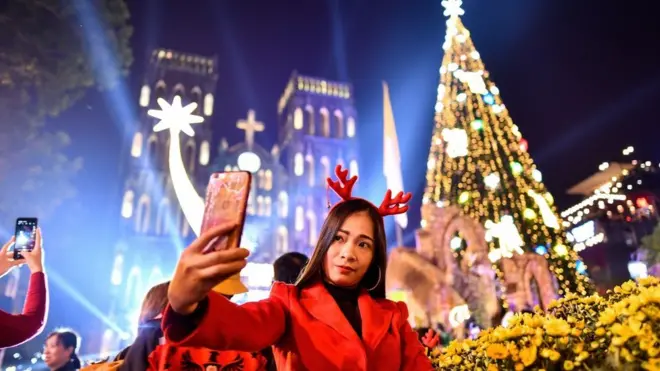 Bir qadın Vyetnamın paytaxtındakı 19-cu əsrə aid Müqəddəs Joseph Katedralının önündə selfi çəkir.