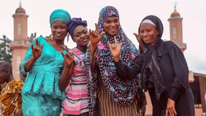 Au Ghana, des jeunes femmes portant des vêtements traditionnels posent pour une photo à l'occasion de l'Aïd.