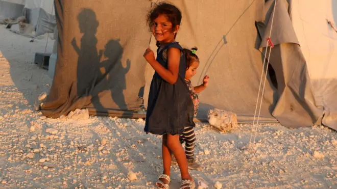 طفلة سورية تقف قرب خيمة لنازحين من محافظة إدلب