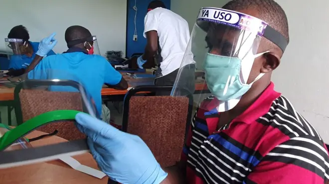 Workers in Dar es Salaam prepare face shields