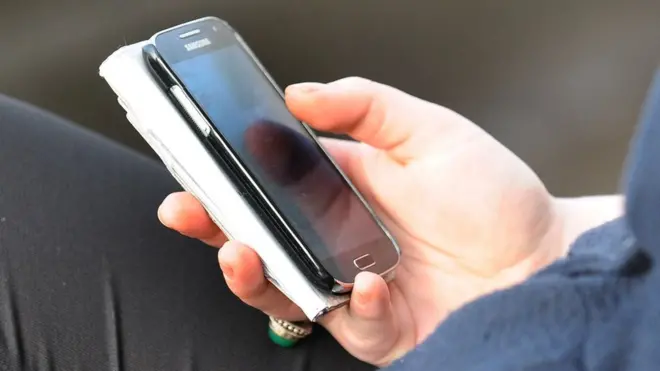 A hand holding a smartphone