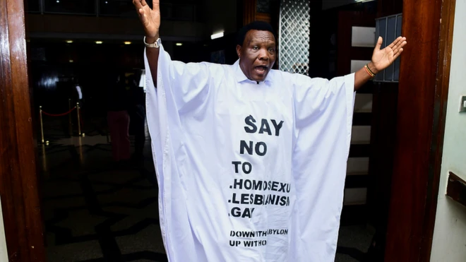 Ugandan MP John Musira dressed in an anti-gay gown as he left parliament chambers