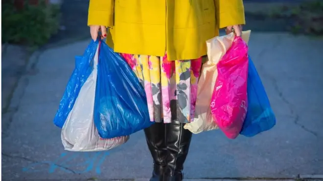 naylon poşet taşıyan bir kadın