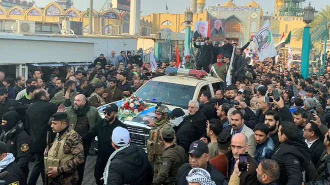 Mourners surround a car carrying the coffin of Qasem Soleimani in Baghdad