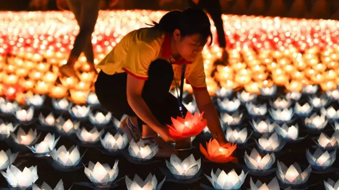 จุดเทียนลงในกระทงกระดาษ วางเรียงรายภายในเจดีย์ที่มีพื้นที่กว้างกว่า 3 หมื่นไร่