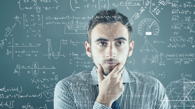 Un hombre frente a un tablero con problemas para resolver