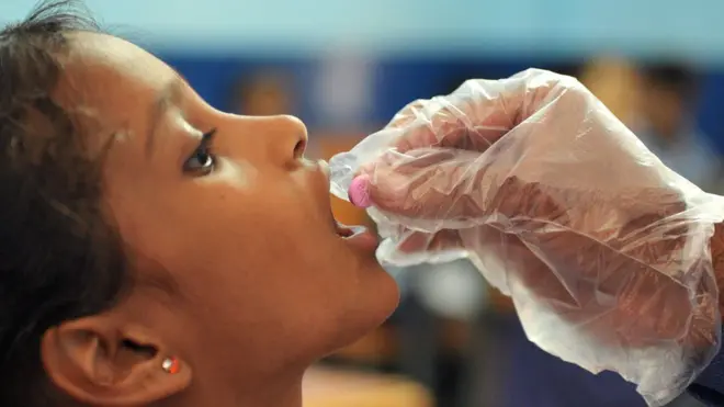 인도의 한 학교에서 교사가 구충제를 나눠주고 있다