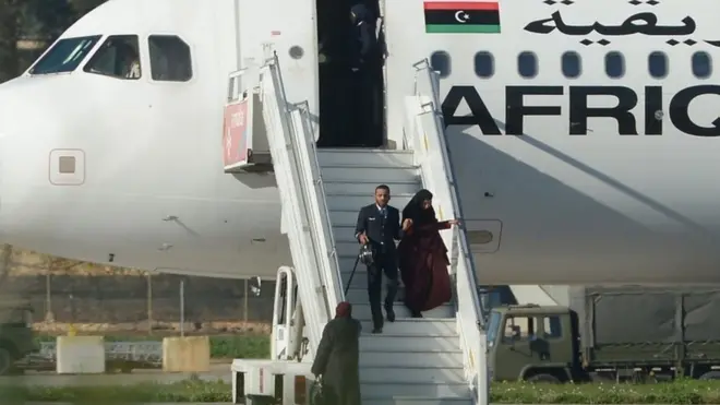 أحد أفراد طاقم الطائرة المختطفة وهو يساعد إحدى الراكبات لدى نزولها في مطار مالطا الدولي