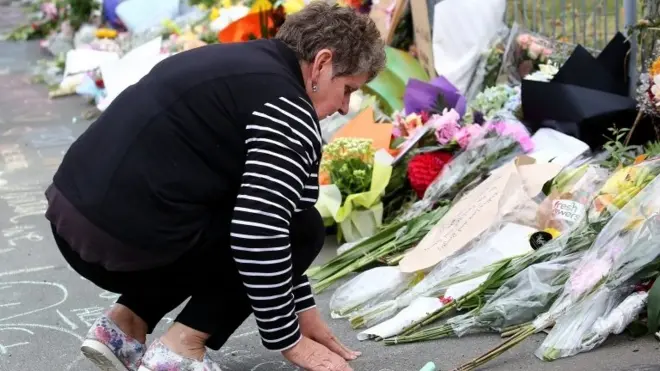 امرأة تضع أكاليل الزهور في موقع الحادث