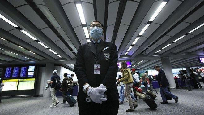 Airport personnel wait for passengers to check their temperature as part of preventive measures against the spread of Middle East Respiratory Syndrome (MERS) at the Hong Kong international airport on June 5, 2015.