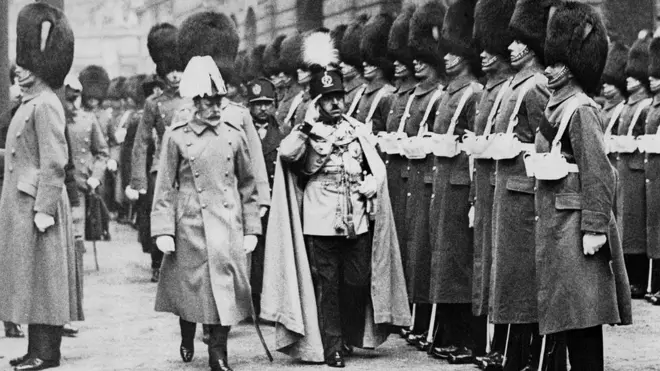 امان الله همراه با جرج پنجم، پادشاه بریتانیای کبیر از برابر گارد احترام در کاخ بکینگام لندن.