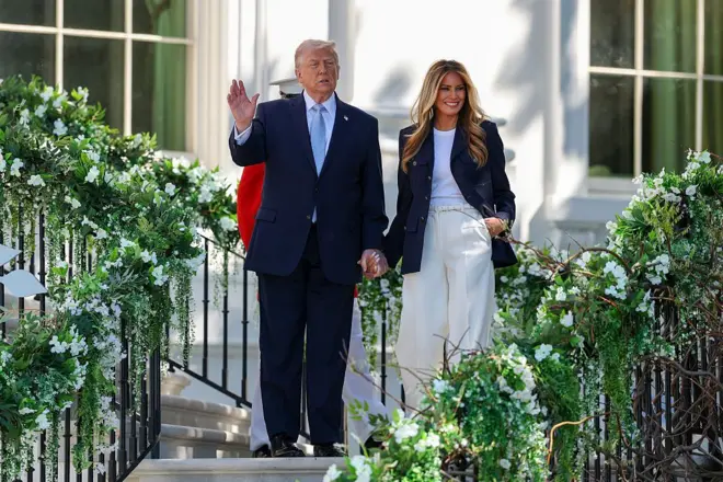 O presidente dos Estados Unidos, Donald Trump, e a primeira-dama, Melania Trump, acenam para os convidados durante o evento “Easter Egg Roll” na Casa Branca, em 6 de abril de 2026