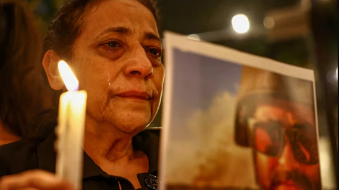 امرأة تحمل صورة وشمعة 