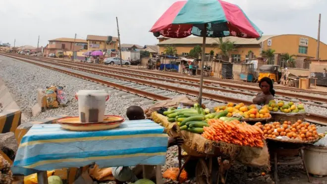 Woman dey sell fruits and vegetable ontop railway track for Lagos