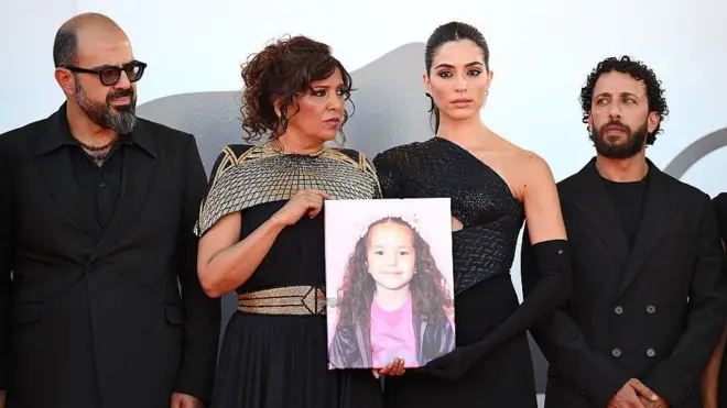 El actor Amer Hlehel, la directora del film Kaouther Ben Hania, la actriz jordano canadiense Saja Kilani y el actor palestino Motaz Malhees con una imagen de Hind Rajab.