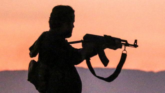 Сирийский боевик с автоматом Калашникова рядом с городом Дараа