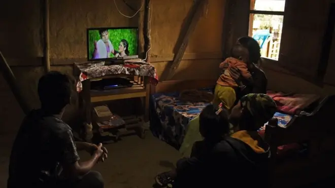 ઘરમાં ટીવી જોતાં લોકો