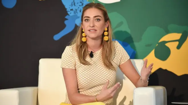 Whitney Wolfe, la fundadora de Bumble sentada en un sofá hablando al público