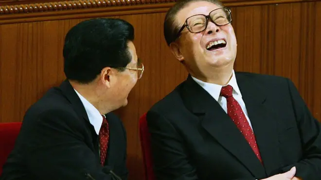 2005年9月3日，在北京，中國前國家主席胡錦濤（左）與江澤民在紀念中國抗日戰爭勝利60週年的會議上交談。