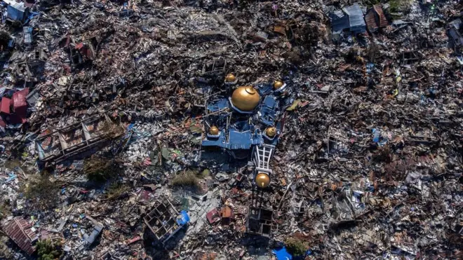 Aerial view of a collapsed mosque amid rubble in