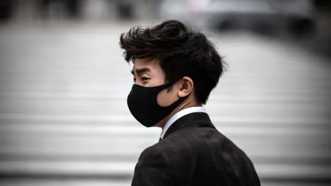 A man wearing a face mask waits to walk over Shibuya crossing on May 25, 2020 in Tokyo, Japan.