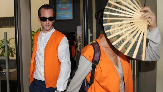 David Taylor (kiri), warga negara Inggris yang didakwa melakukan pembunuhan tak direncanakan, bergandengan tangan dengan Sara Connor, warga Australia yang juga didakwa dengan tuduhan yang sama.