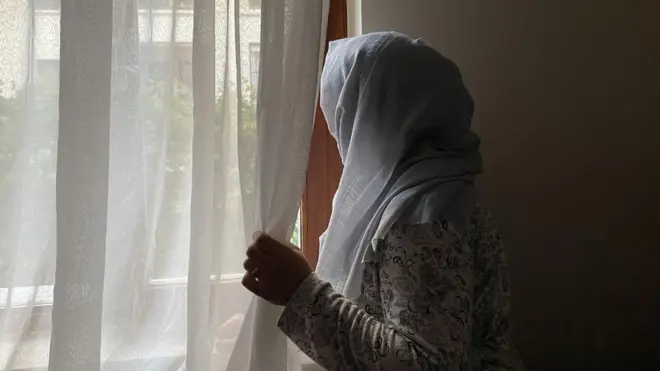 camdan bakan bir afgan kadın