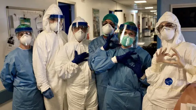 Members of staff at the hospital make heart signs to the camera