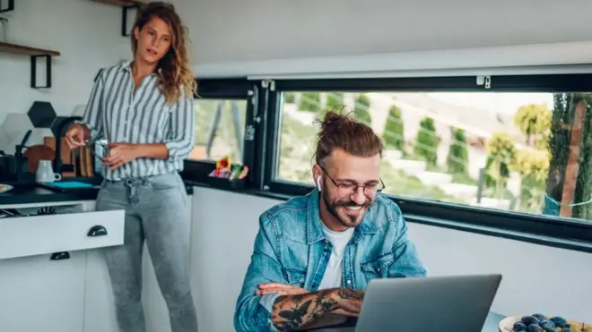 Жена посматра док њен партнер ради