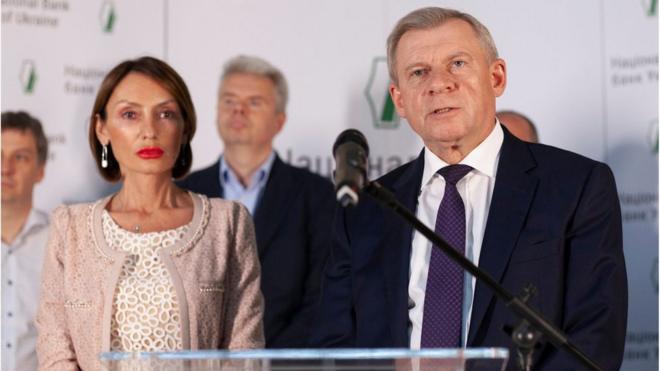 Катерина Рожкова (ліворуч) та Дмитро Сологуб (позаду) були поруч із тодішнім головою НБУ Яковом Смолієм, коли він заявляв про свою відставку через політичний тиск
