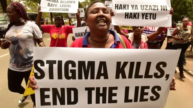 Une activiste brandit une pancarte sur laquelle on peut lire "La stigmatisation tue, mettez fin aux mensonges'' au Kenya
