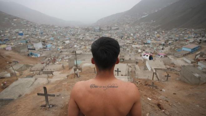 Sepulturero mira hacia un cementerio en las afueras de Lima, Perú.