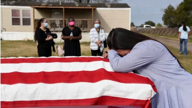 A family says goodbye to their father's flag draped coffin