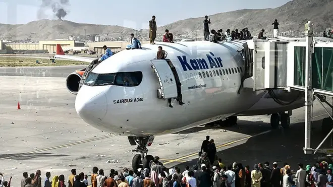 مواطنون يصعدون على متن طائرة تقف في مطار كابل
