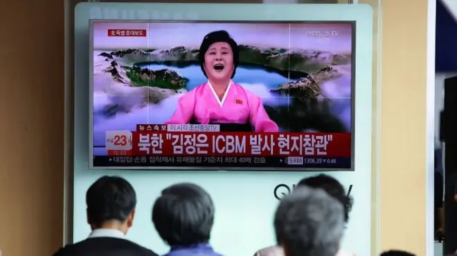 People watch a North Korean state television show as a presenter announces North Korea has test-launched its first intercontinental ballistic missile at the Seoul Railway Station on 4 July 2017 in Seoul, South Korea