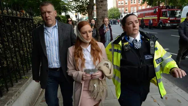 The ambulance service said a number of people had been injured, but none had sustained serious or life-threatening wounds. This woman was photographed as she was escorted from the scene by a police officer
